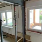 Das Innere des Hauses wird gerade renoviert und verfügt über freiliegende Balken, Stützstreben und zwei Fenster, die natürliches Licht hereinlassen.
